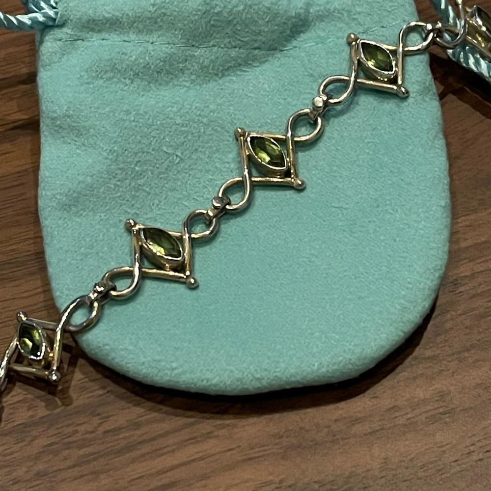 Beautiful green peridot gemstones in fancy silver setting, with fabric gift bag